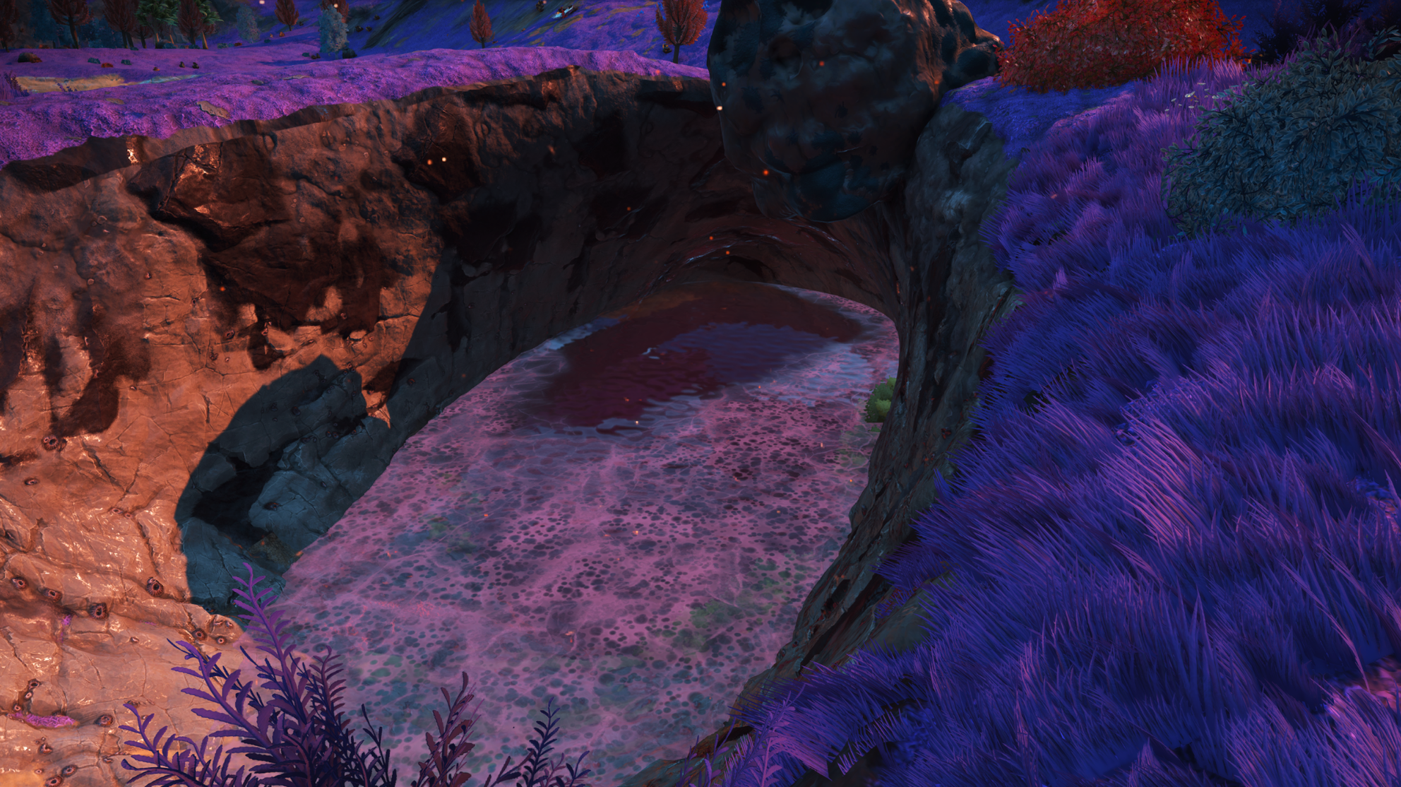 Pink-water channel beneath a rock formation at Serene Basin